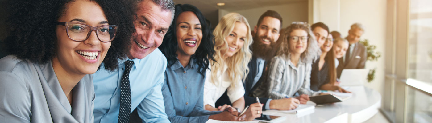 Cheerful multiracial colleagues looking at camera in office